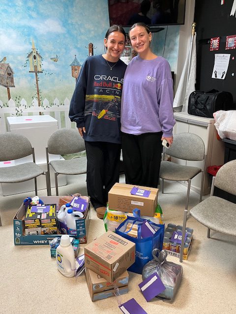 Volunteers posing with collected donations including cleaning supplies and pet items for STAF from 84.51