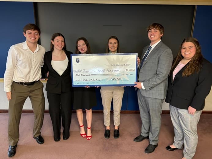 Mount St. Joseph students presenting a donation check to Save the Animals Foundation