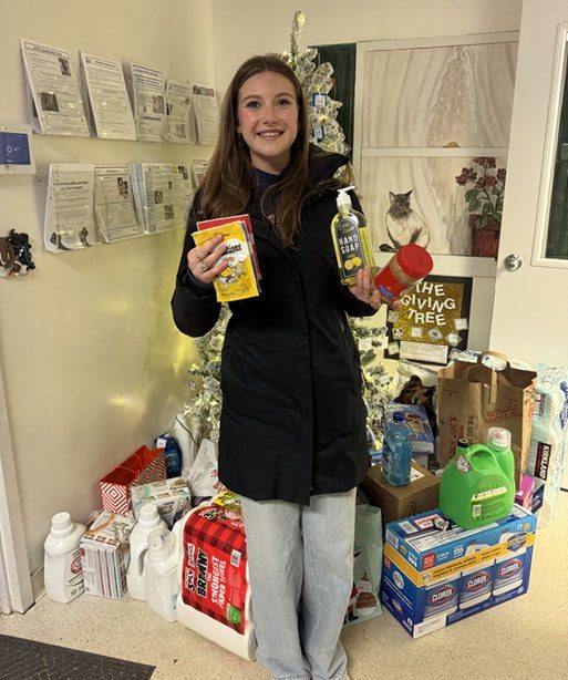 Eva, a Walnut Hills senior, holding donated supplies for STAF