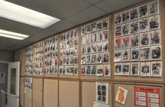 Wall covered with photos of adopted pets and their new families