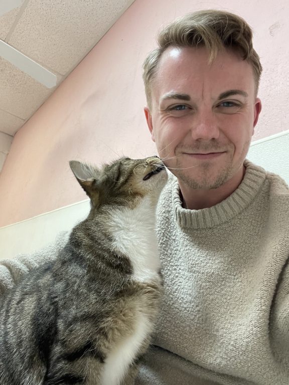 Volunteer poses with a cat at the shelter.